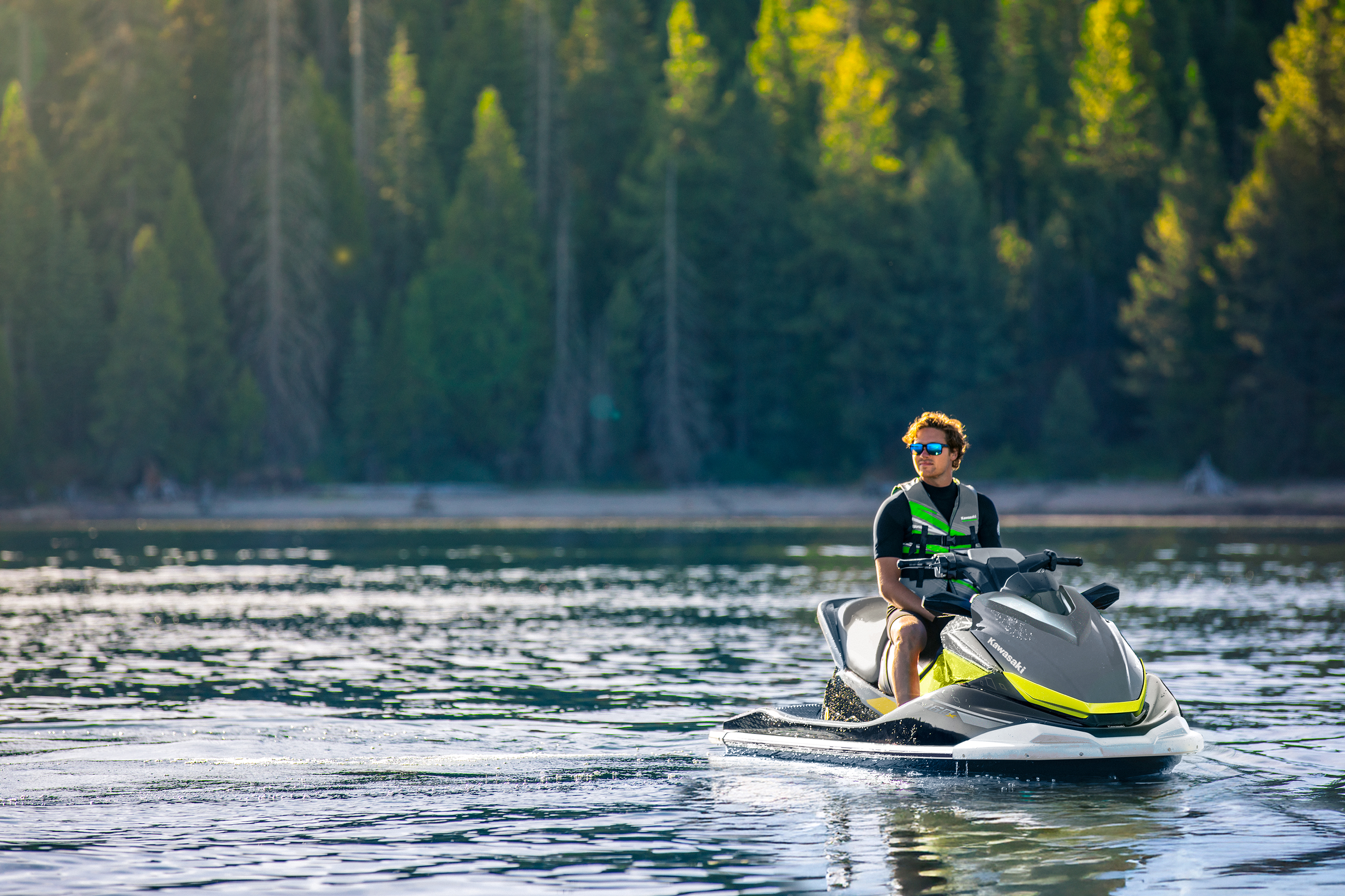 Personal watercraft cruising a forested lake